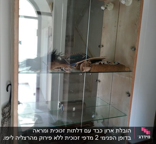 בובת עץ בתצוגה בארון זכוכית עם מדפים